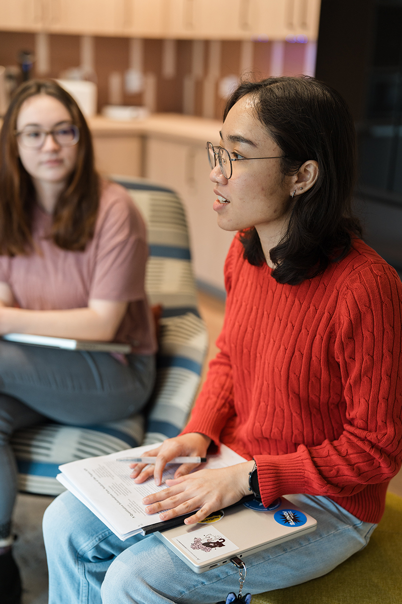 Two seated students discussing classwork