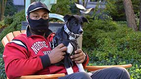 Jordan Clark seated with his dog, Riou