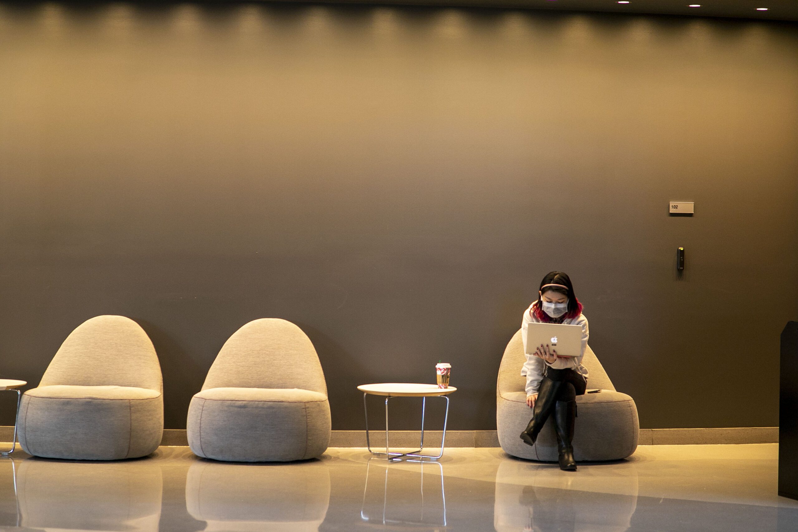 student sitting alone at a chair doing work