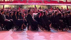 Khoury College graduates watch Dean Elizabeth Mynatt deliver a speech at the 2022 Khoury celebration