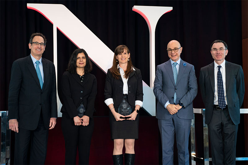 Professors Tina Eliassi-Rad (second from left) and Alicia Sasser Modestino (center) accept awards, joined by President Joseph Aoun (second from right), Senior Vice Provost for Research David Luzzi (far left), and Provost/Senior VP for Academic Affairs David Madigan (far right). Photo by Alyssa Stone/Northeastern University 