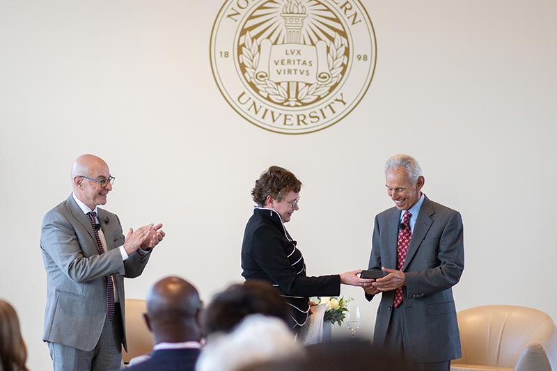 Mynatt presents Dr. Khoury with the first of the college’s 40 for 40 Honors as Northeastern President Joseph Aoun looks on. Photo by Miles Chun.