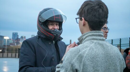 President Aoun talks to a student while wearing his driving helmet