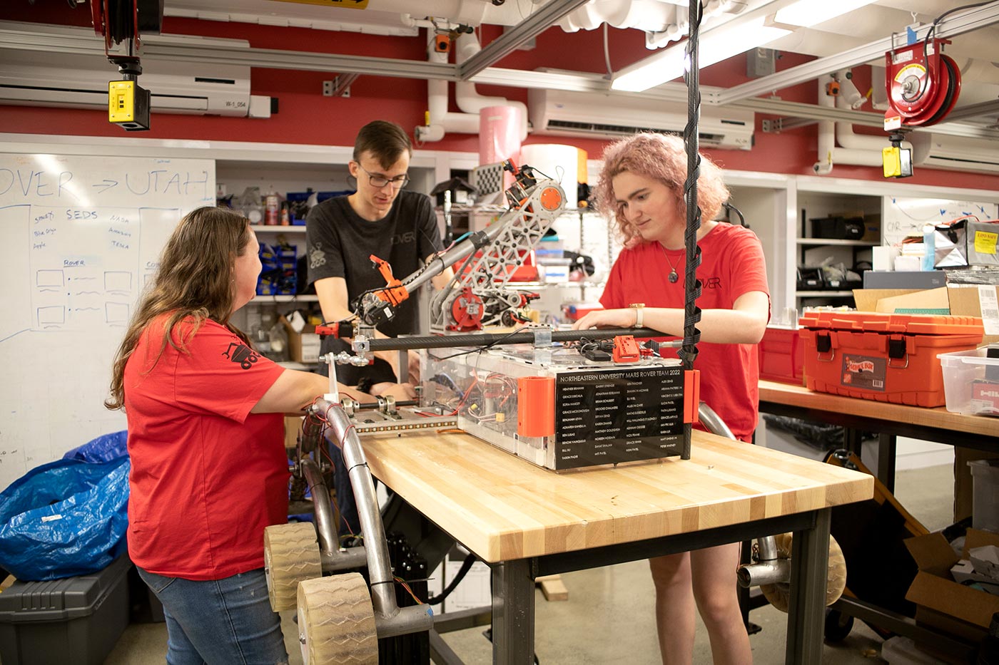 From left to right: Shannon McInnis, Garrit Strenge, and Brooke Chalmers work on the rover. Photo by Sarah Olender.