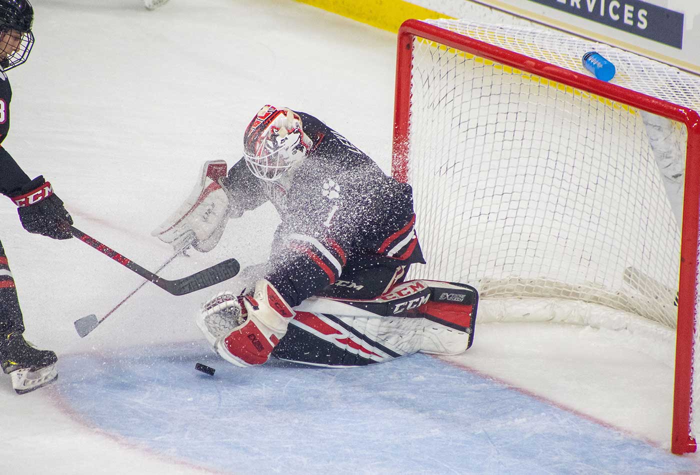 Devon Levi makes a save while bits of ice fly in his face