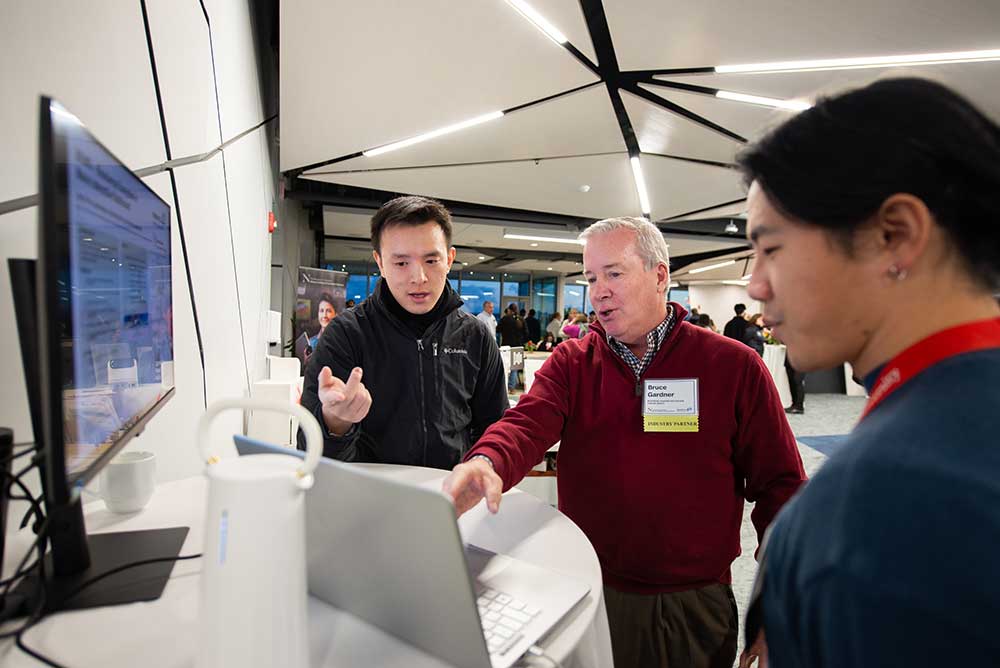 Hao Sheng (Jack) Ning, student, and GunGyeom (James) Kim present their project to an industry partner at the 40th Anniversary Celebration at the Roux Institute in Portland, ME.