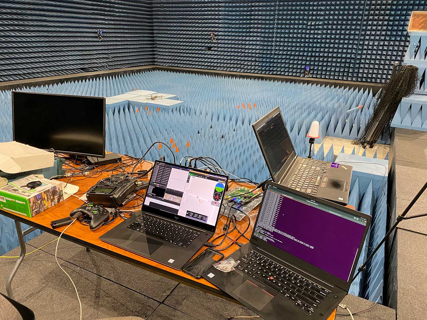 Two small drones fly in a lab