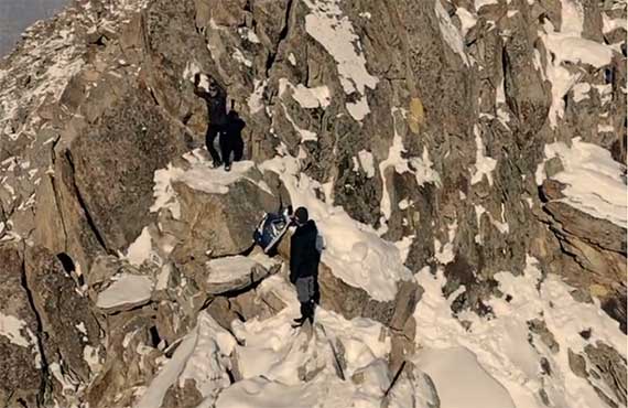 a photo showing a video frame from the study's dataset; the researchers are shown on top of a snowy hill