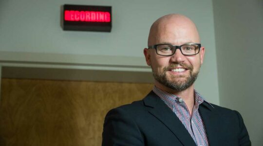 Matthew Goodwin stands in front of a recording studio