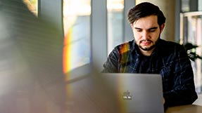 Justin Diament works at a laptop. Photo by Matthew Modoono/Northeastern University