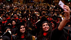 Graduates take a selfie at the Seattle commencement. Photo by Matthew Modoono/Northeastern University