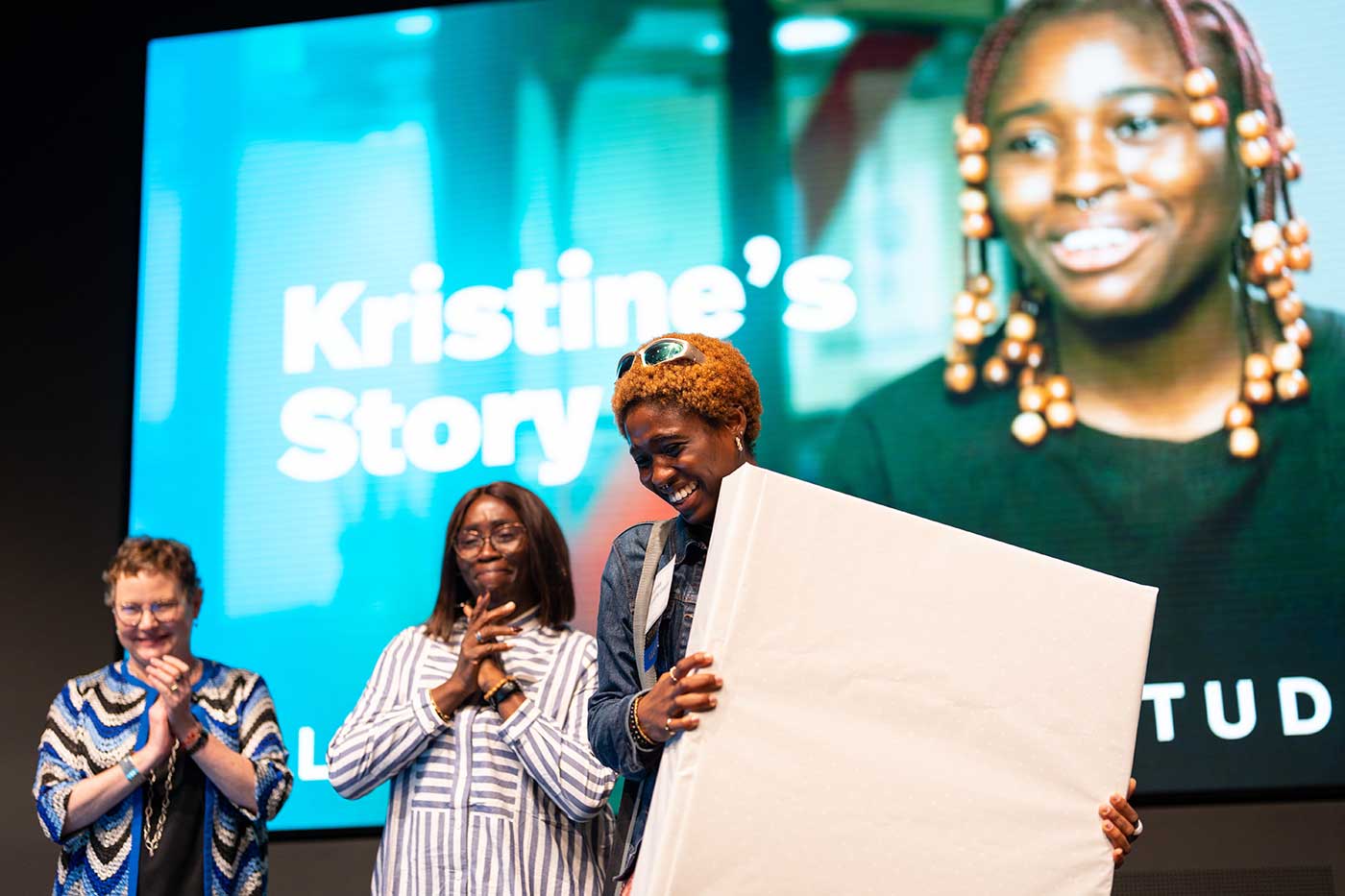 Kristine Umeh accepts a gift from Dean Beth Mynatt as Kristine's mother looks on. Photo by Ian MacLellan.