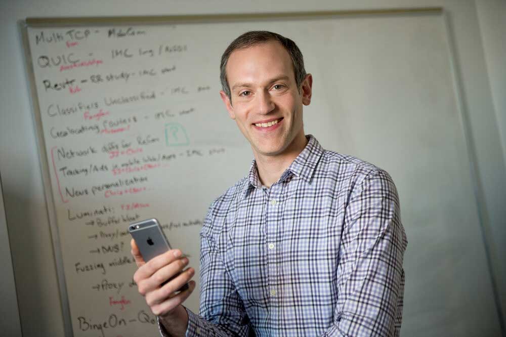 Dave Choffnes holding a mobile device