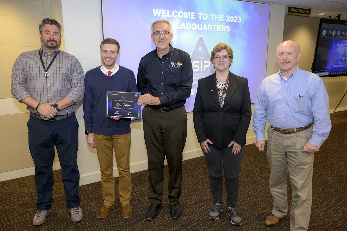 Owen Seltzer is awarded a certificate as he stands with a team from NASA.