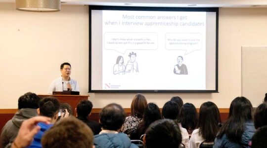 Ji-Yong Shin speaks at a podium