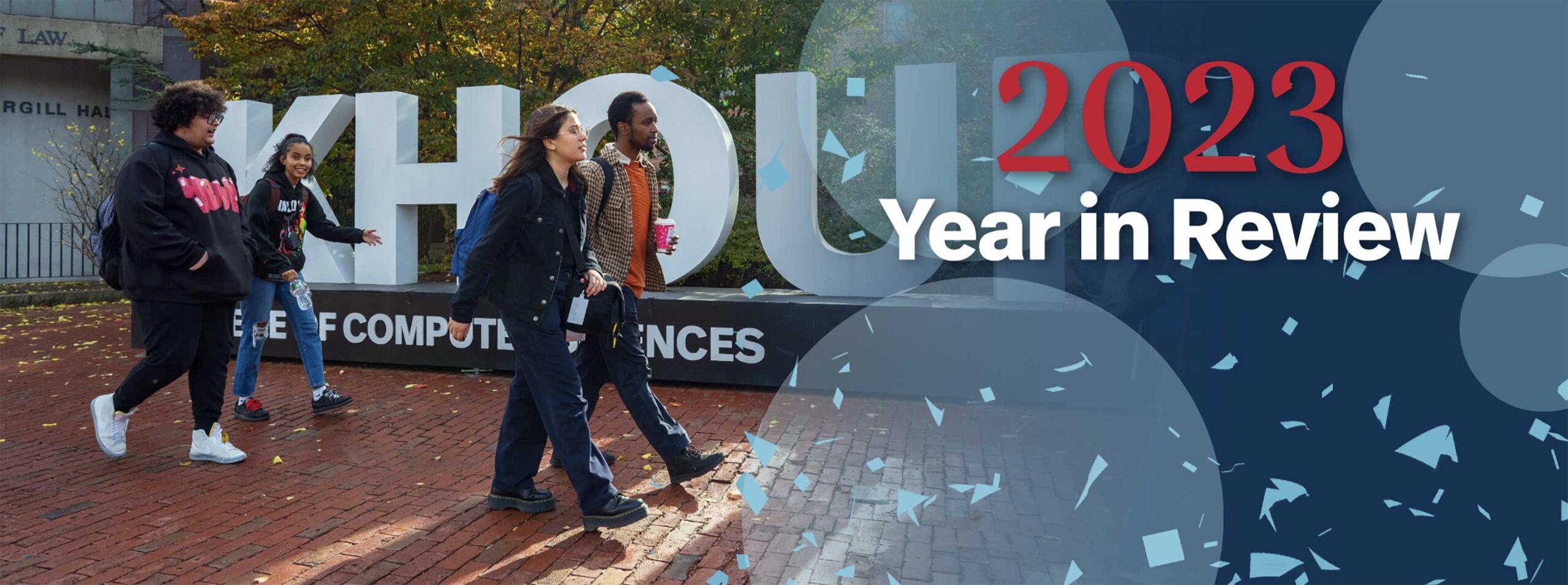 Students walk by the Khoury College of Computer Science sign on the sidewalk along Huntington Avenue