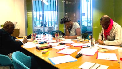 A photo of three people sitting around a table at a focus group