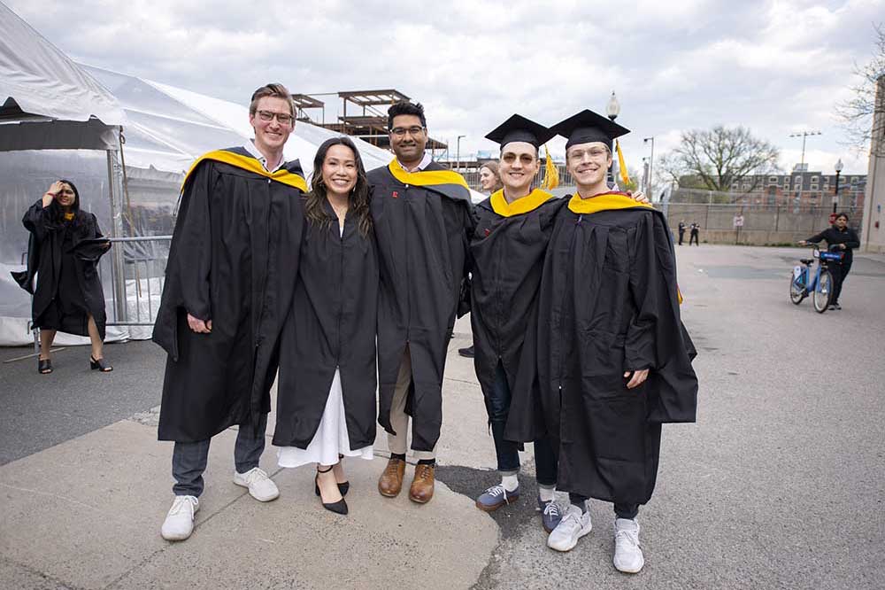 Five students pose outside Matthews Arena on May 2, where some 900 undergraduate and graduate students celebrated their accomplishments.