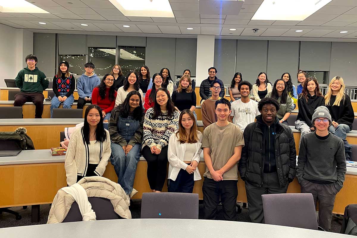 About 30 members of code4community pose for a photo taken in a Northeastern classroom during a club meeting.