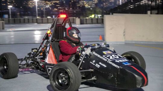 Dean Elizabeth Mynatt drives Northeastern Electric Racing's car in a Northeastern parking lot.