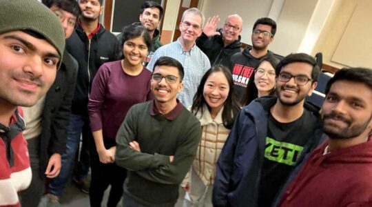 Thirteen members of the null NEU club smile while they pose for a selfie.