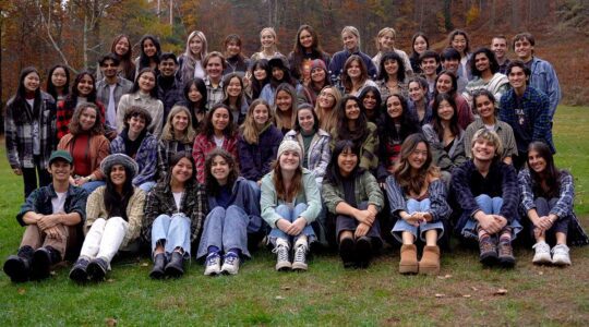 Approximately 50 members of scout pose for a photo in an outdoor field.