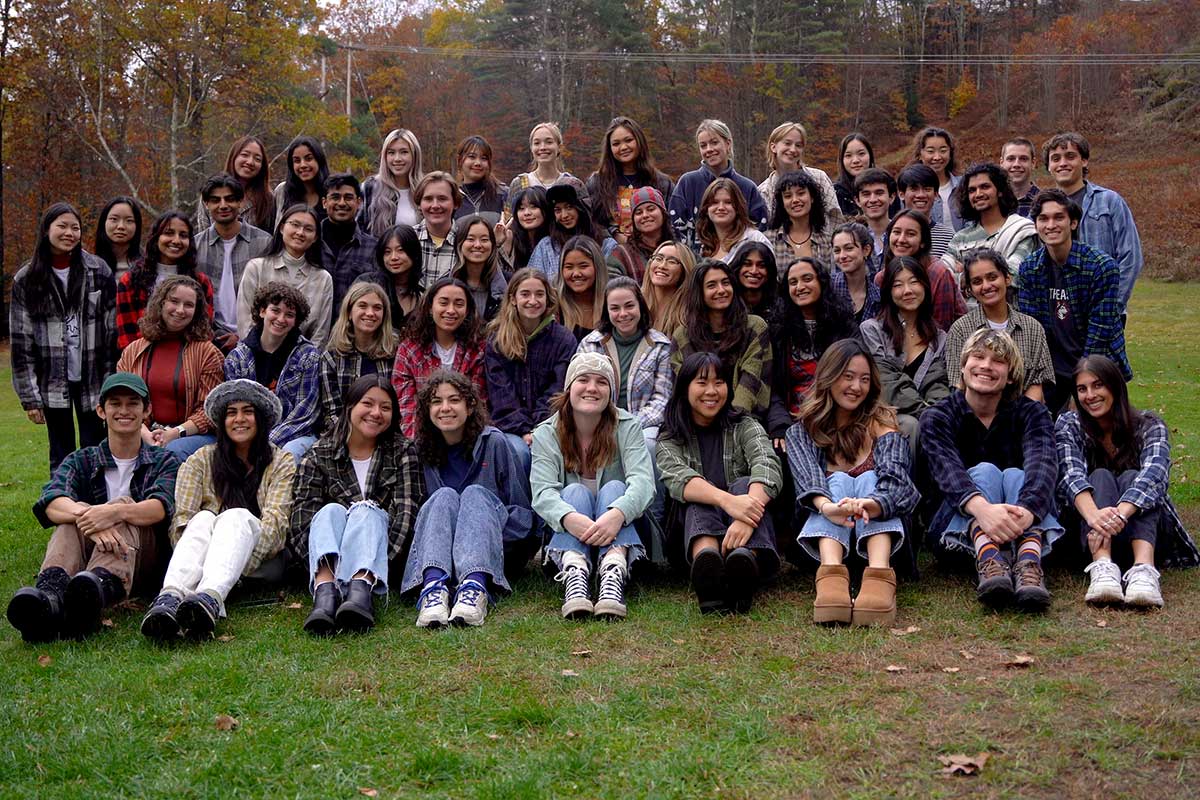 Approximately 50 members of scout pose for a photo in an outdoor field.