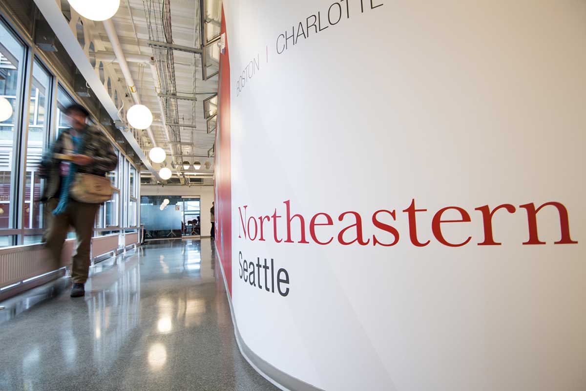 A student walks through a hallway at the Seattle campus, which is a modern campus with a contemporary vibe.