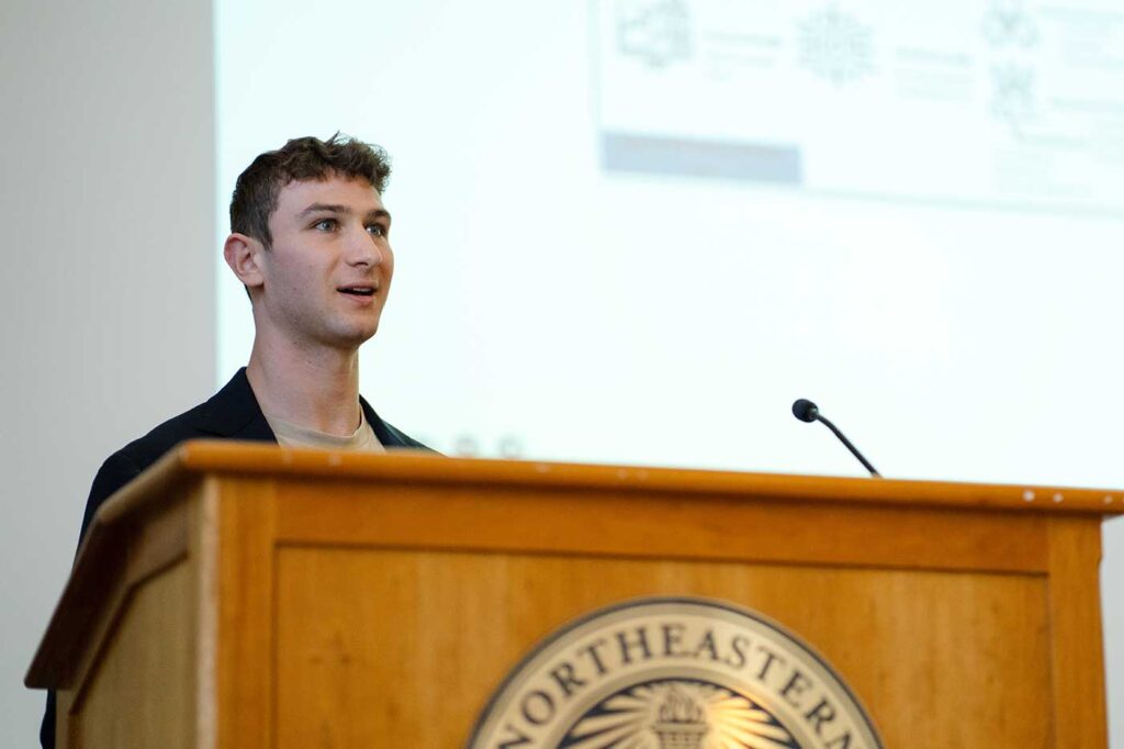 Alex Crystal presents his project standing behind a podium