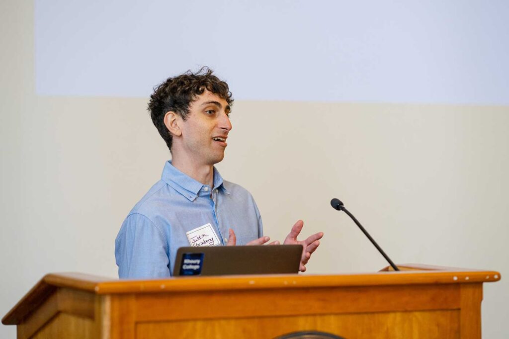 Justin Steinberg presents a project while standing behind a podium