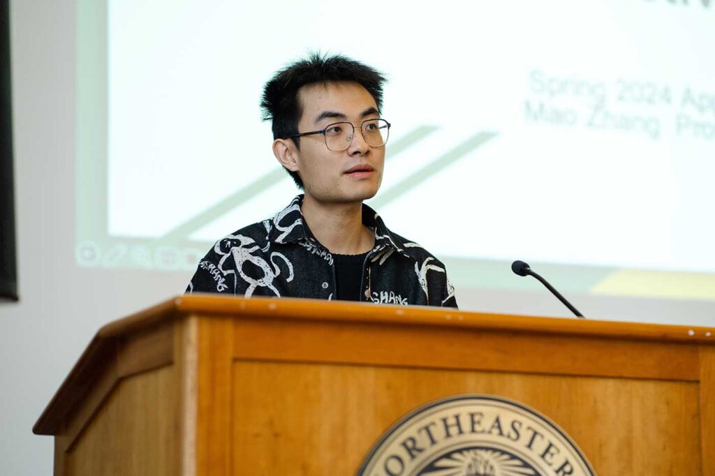 Mao Zhang presents a project while standing behind a podium