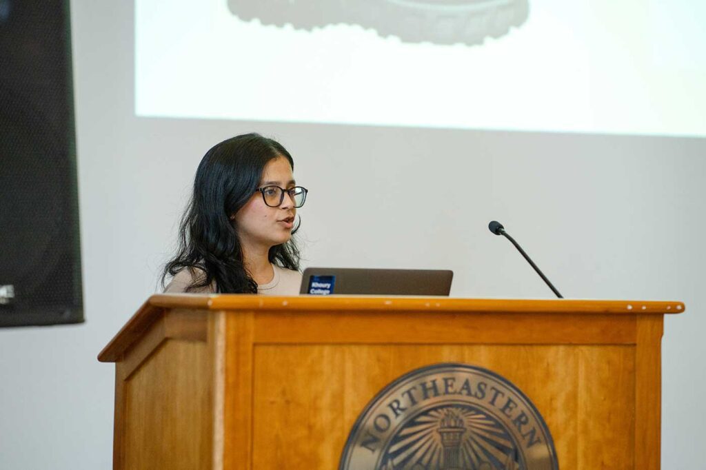 Vamshika Lekkala presents a projects while standing behind a podium