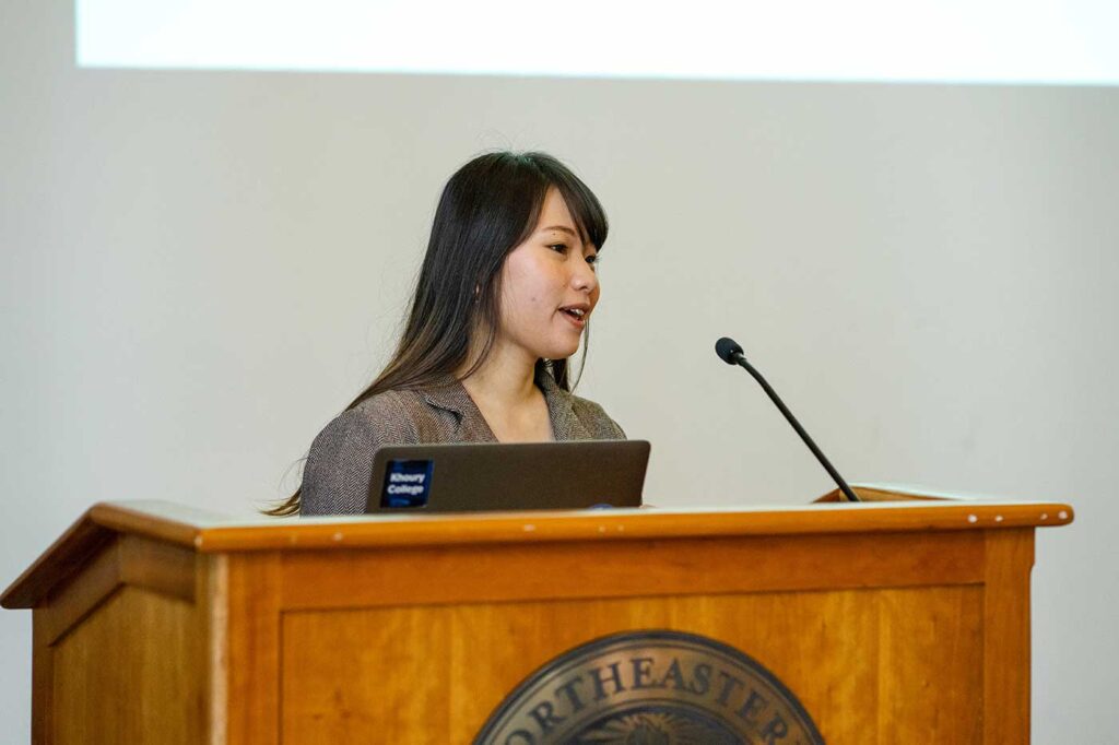 Wing Sum Poon presents a project while standing behind a podium