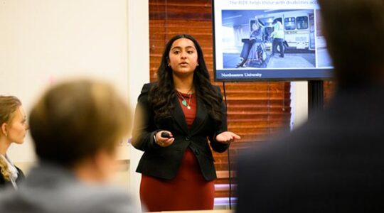 A Khoury student speakers to a an audience about her project related to transporting medical patients