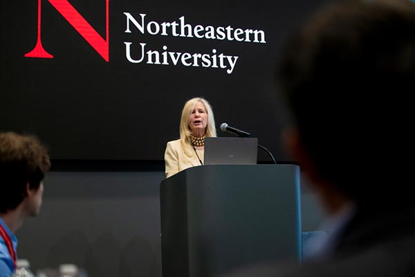 A member of Northeastern's administration speaks behind a black podium