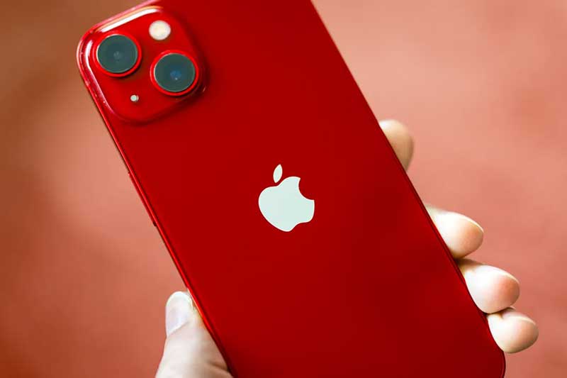 A hand holds a red iPhone