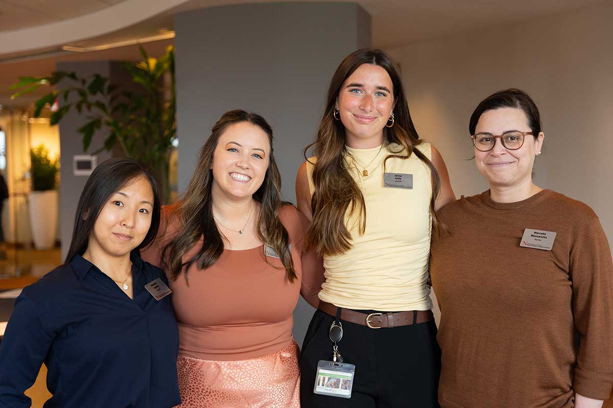 Four Khoury staff members pose for a photo in a conference room