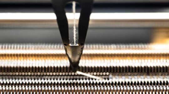 Megan Hofmann’s knitting machine creates a shawl for Elizabeth Mynatt. Mynatt wore the shawl for her American Academy of Arts and Sciences induction. Photo by Alyssa Stone/Northeastern University