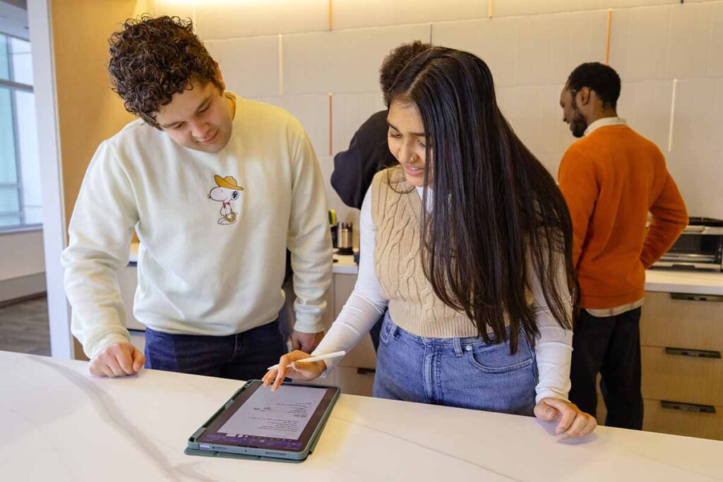 Two students work on an iPad