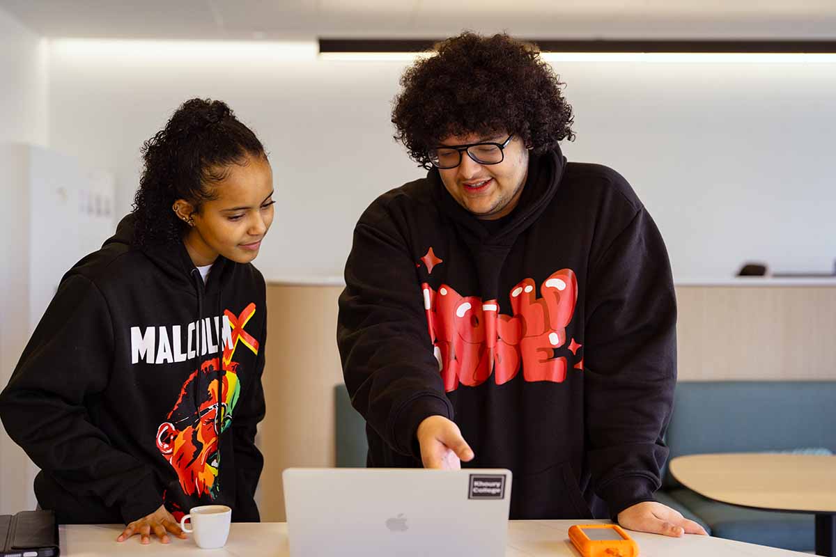 Two students work on a laptop