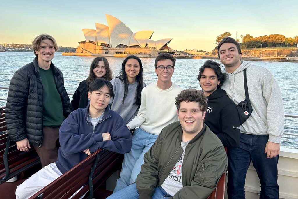 8 Khoury students pose for a photo with the Sydney Opera House in the background