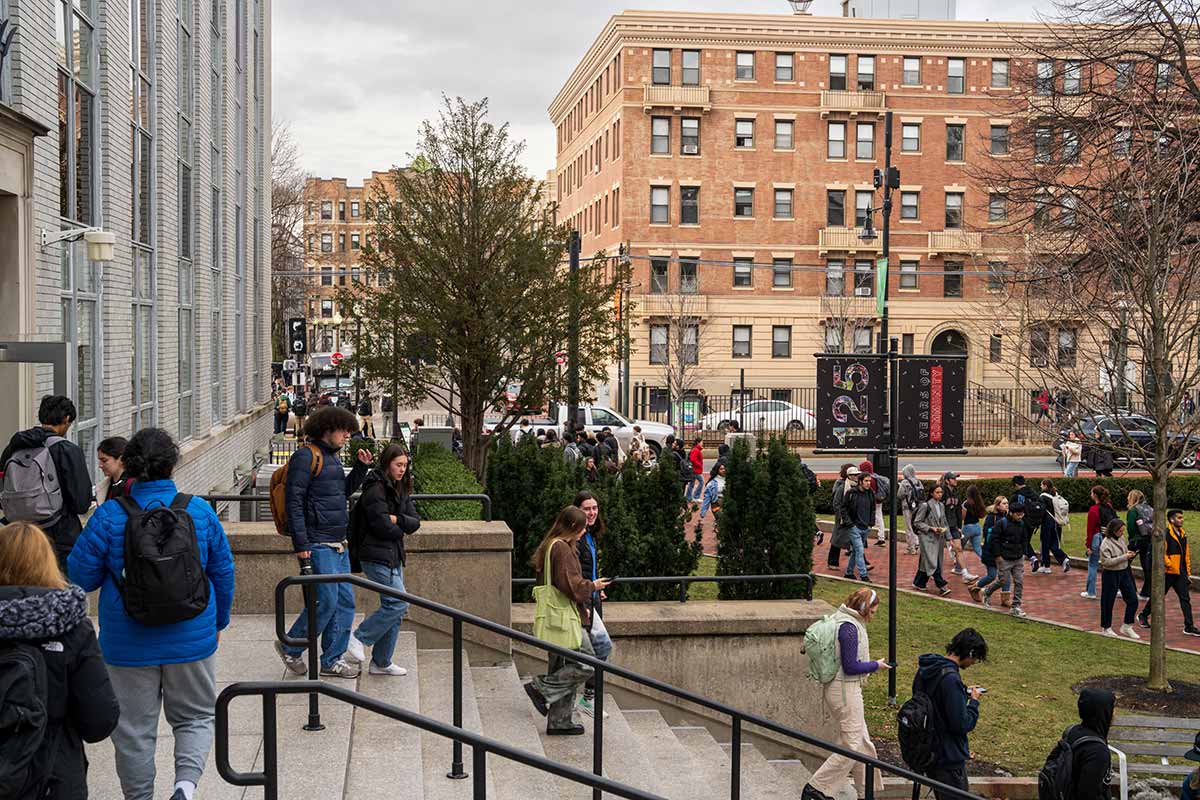 Students walk down steps exiting a building at Northeastern's campus in Boston