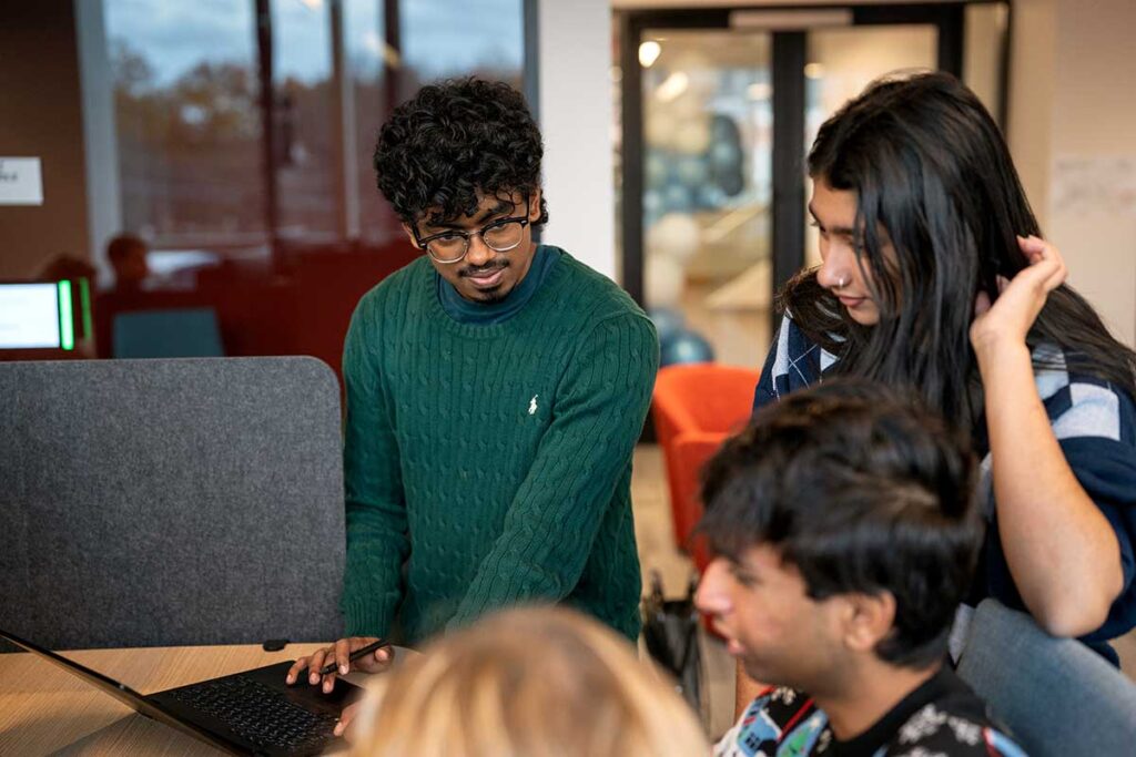 Three Khoury students discuss a project in a Khoury lab