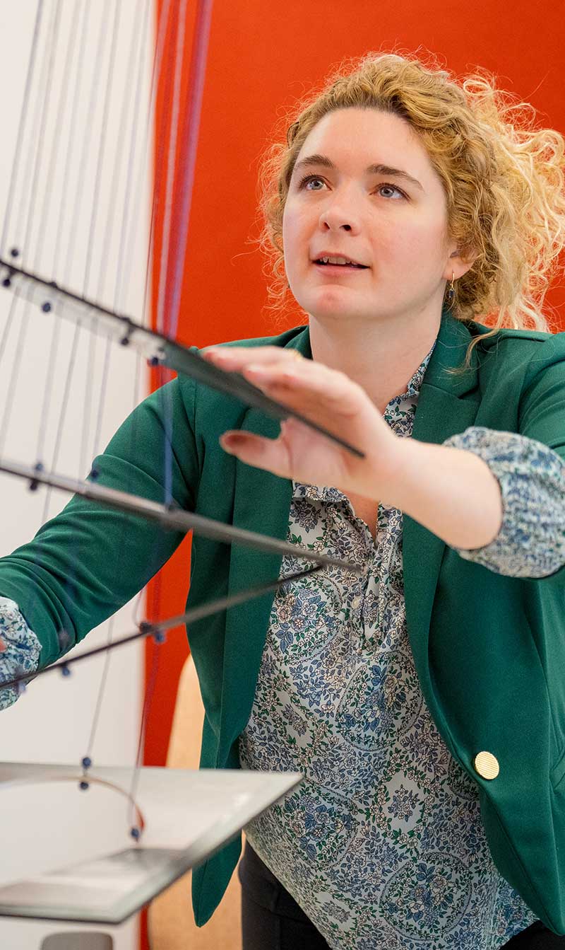 A researcher holds on to pieces of plastic attached to several strings