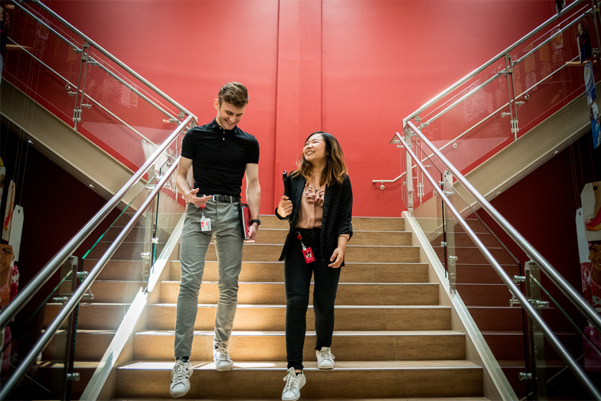 Two people walk down stairs