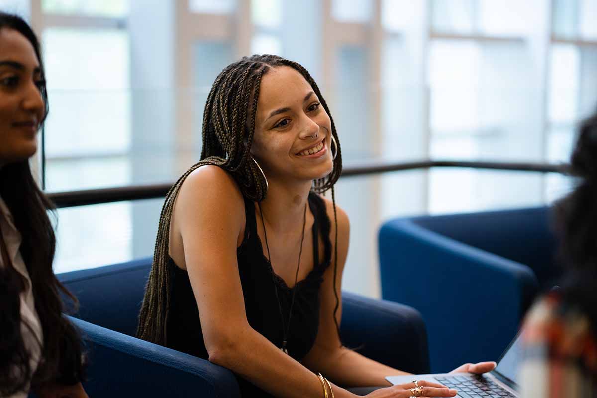 A student smiles as she sits with friends