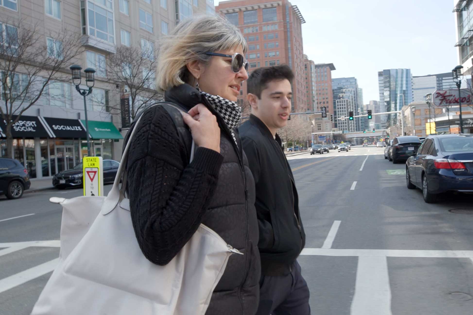 Cathy Bilotta walks across a Boston street with her son.