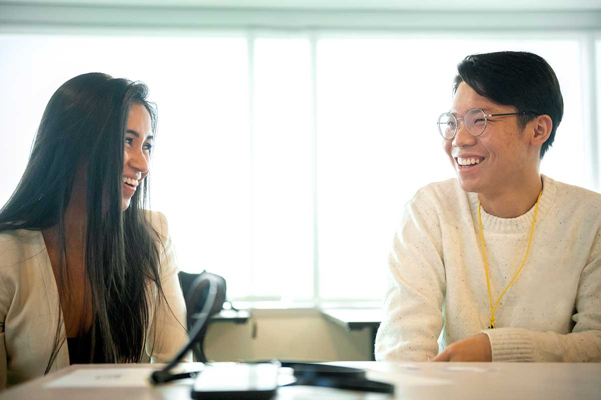 Two Align student smile while having a conversation in a Khoury classroom