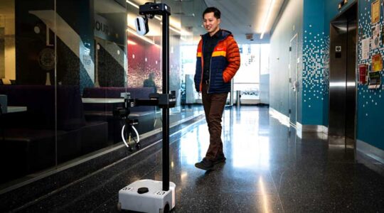 Computer science professor Zhi Tan follows a robot nicknamed ‘Marlo’ to the restrooms of the West Village H Northeastern’s Boston campus. Photo by Alyssa Stone/Northeastern University