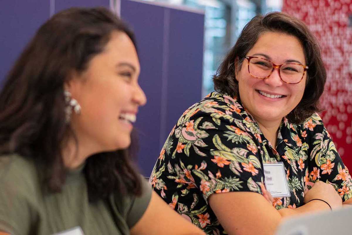 Two people smile during a presentation in a Khoury lab